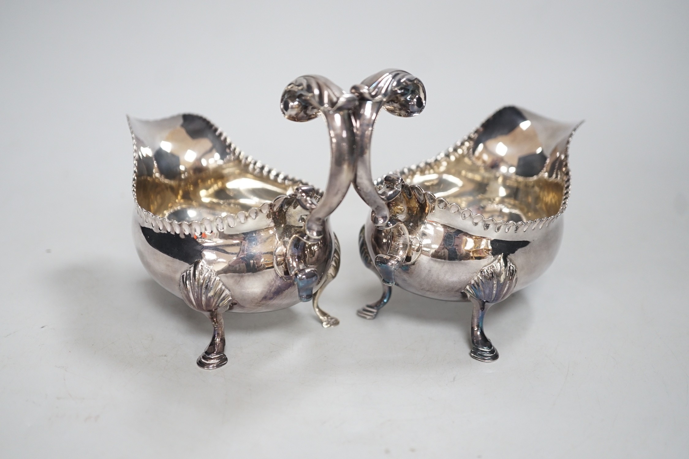 A pair of early George III silver sauceboats, with flying scroll handles, maker, CH, London, 1768, length 15.5cm, 10.4oz.